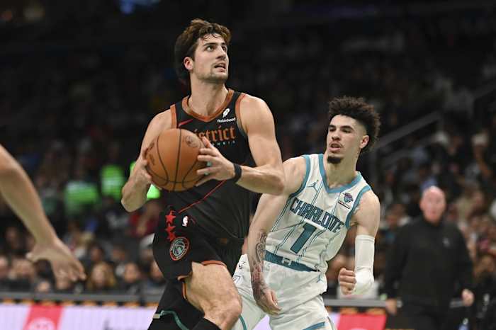 Washington Wizards forward Deni Avdija (8) makes aa move to the basket y Charlotte Hornets guard LaMelo Ball (1) during the first half at Capital One Arena.